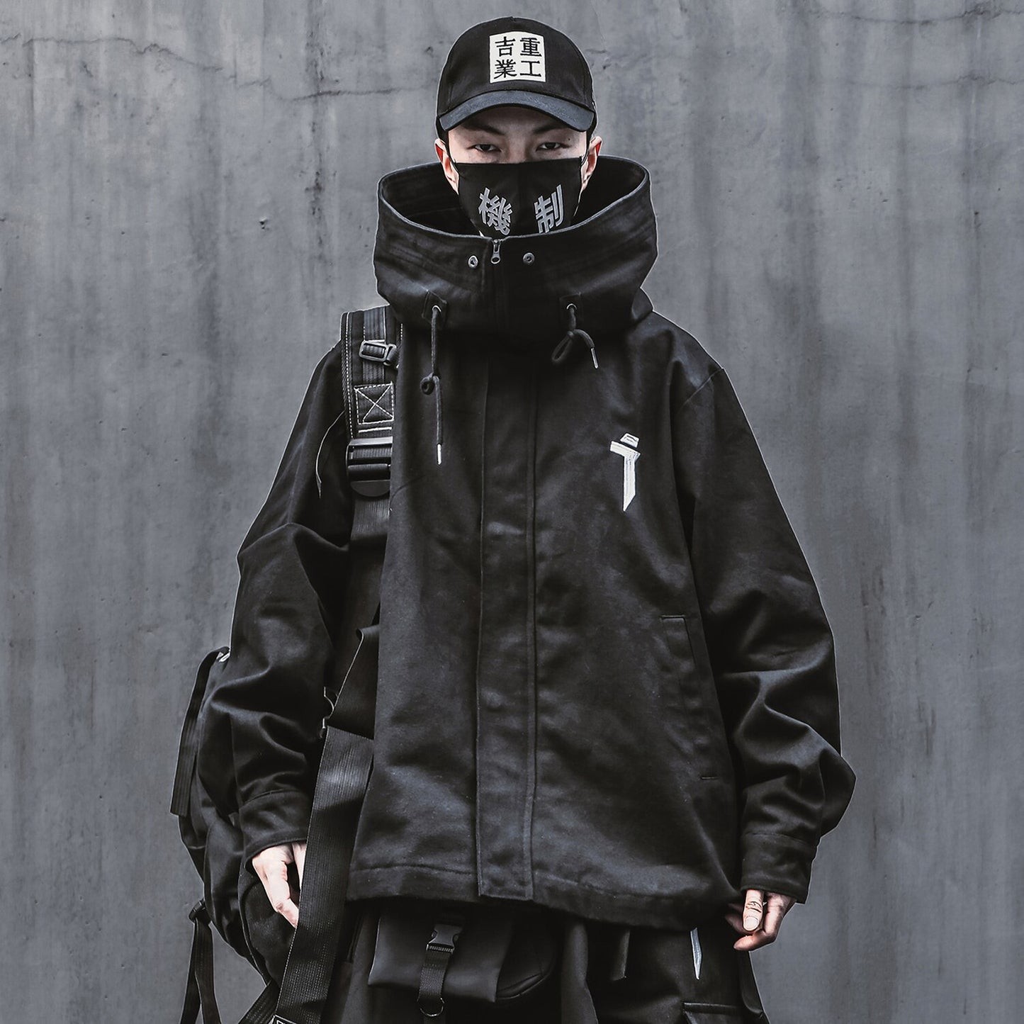 Jaqueta masculina com capuz e gola alta com zíper. Esta jaqueta exclusiva é inspirada na moda japonesa de streetwear e techwear, reunindo forma e função em uma peça marcante. Confeccionada com atenção aos detalhes.